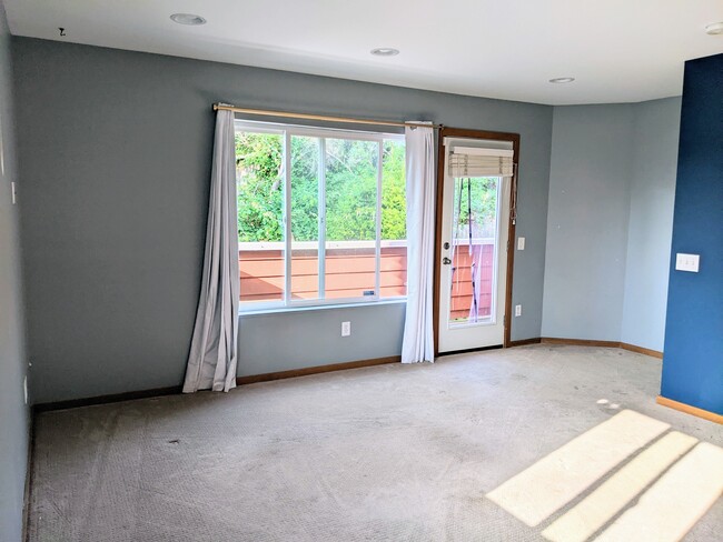 Living room with view of balcony to backyard that overlooks trees and terraced garden - 4810 S Holly St