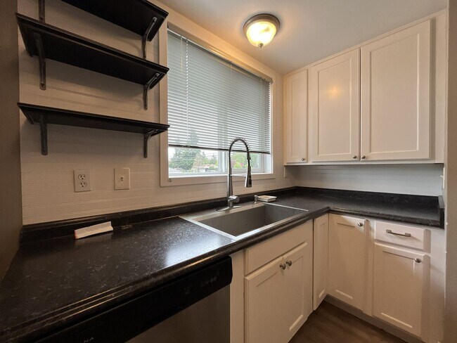 Building Photo - Three-Bedroom Home with Updated Kitchen & Vaulted Ceilings, large open basement, Hardwood floors