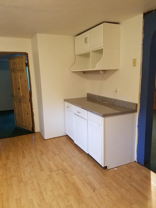 Kitchen, north wall with entry to first floor Bedroom. Laminate plank flooring. - 15 Goodrich St