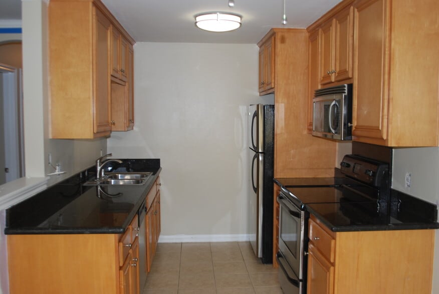 Double sink, disposal, dishwasher, microwave, oven, and refrigerator - 9929 Erma Rd