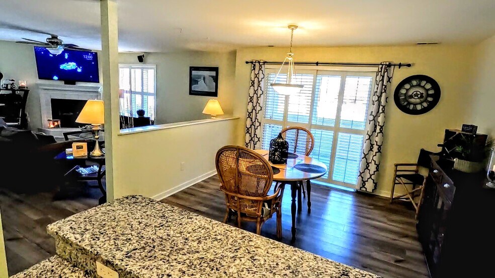View of the dining and living areas from behind the bar in the kitchen. Entrance to porch. - 424 Commerce Ave
