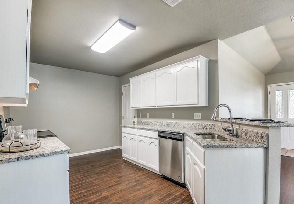 A newly remodeled kitchen with white cabinets, floors, and stainless steel appliances gives you a modern style to live in. - 2066 Bentwood Dr