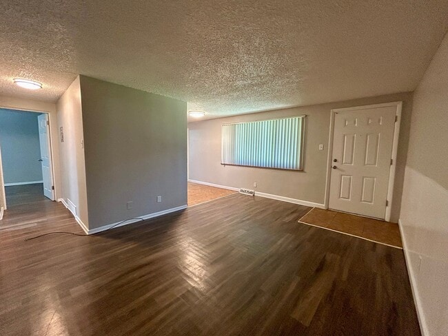 Inviting apartment interior with sleek hardwood floors, bright lighting, and a welcoming entrance area. - Boardwalk Apartments