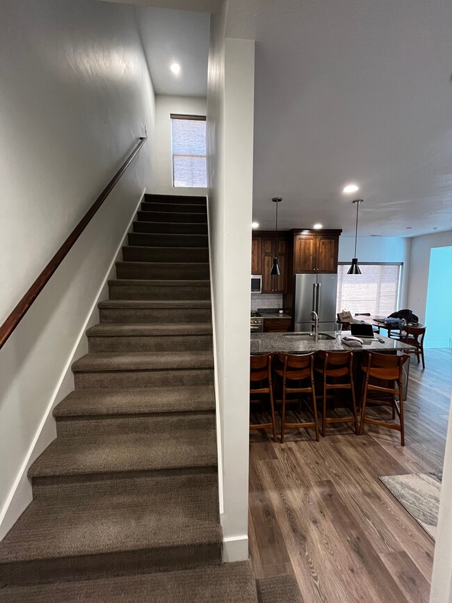 Tight weave earth tone carpet and textured wood laminate floors. Going up. - 361 W Reed Ave