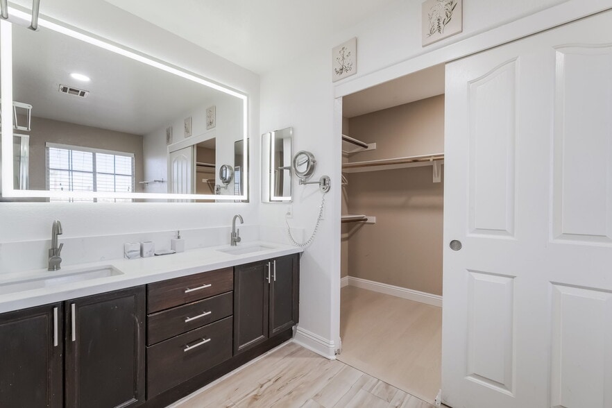 Bathroom with double vanity, light wood-style flooring, and a walk in closet - 1179 Antoinette St