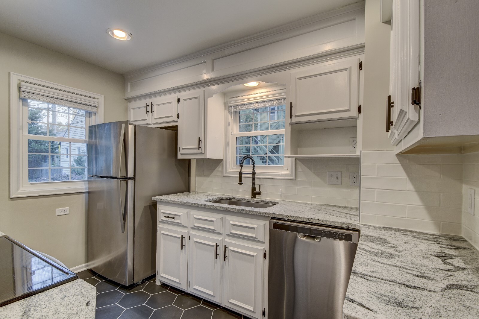 NEW hexagon tile flooring, quartz counters, stainless steel appliances, black hardware, sink, faucet, subway tile backsplash, paint, and blinds. - 5210 Rees St