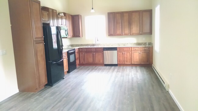 Luxury vinyl plank flooring throughout open concept kitchen, dining and living room - 1 E. Main St.