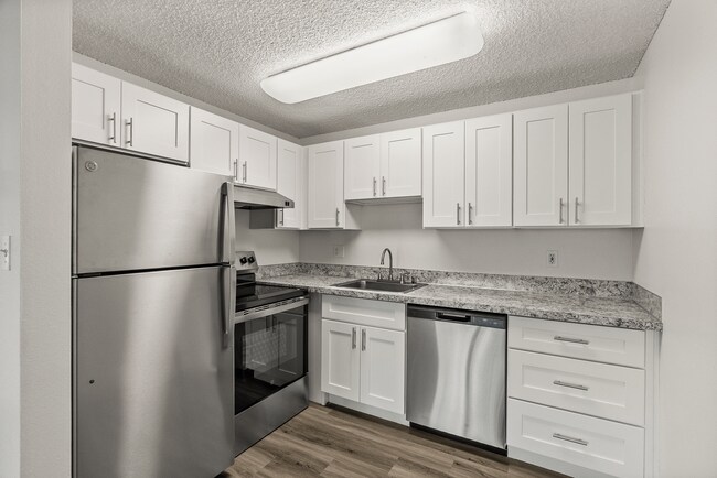 Enjoy cooking in a bright, modern kitchen featuring stainless steel appliances, sleek cabinetry, and stylish countertops designed for everyday living. - Bay Ridge Apartments