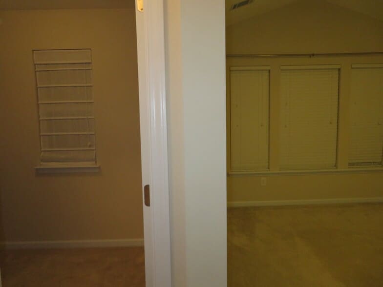 Master Suite - Closet/Dressing Room on left at the entrance w Roman blind, Bedroom on right w blinds - 2496 Stadium Dr