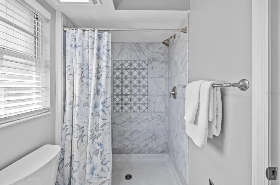 Spacious walk-in shower with fresh tile and modern finishes. - 1932 Brainerd Ct