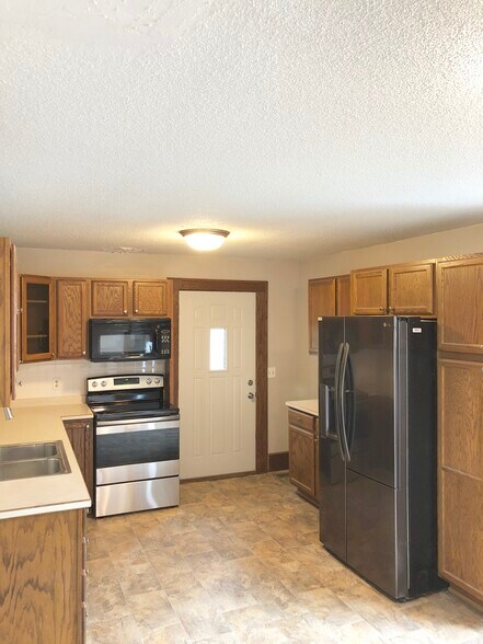 Kitchen with new refrigerator and stove! Tons of cabinet space. - 816 3rd St SE