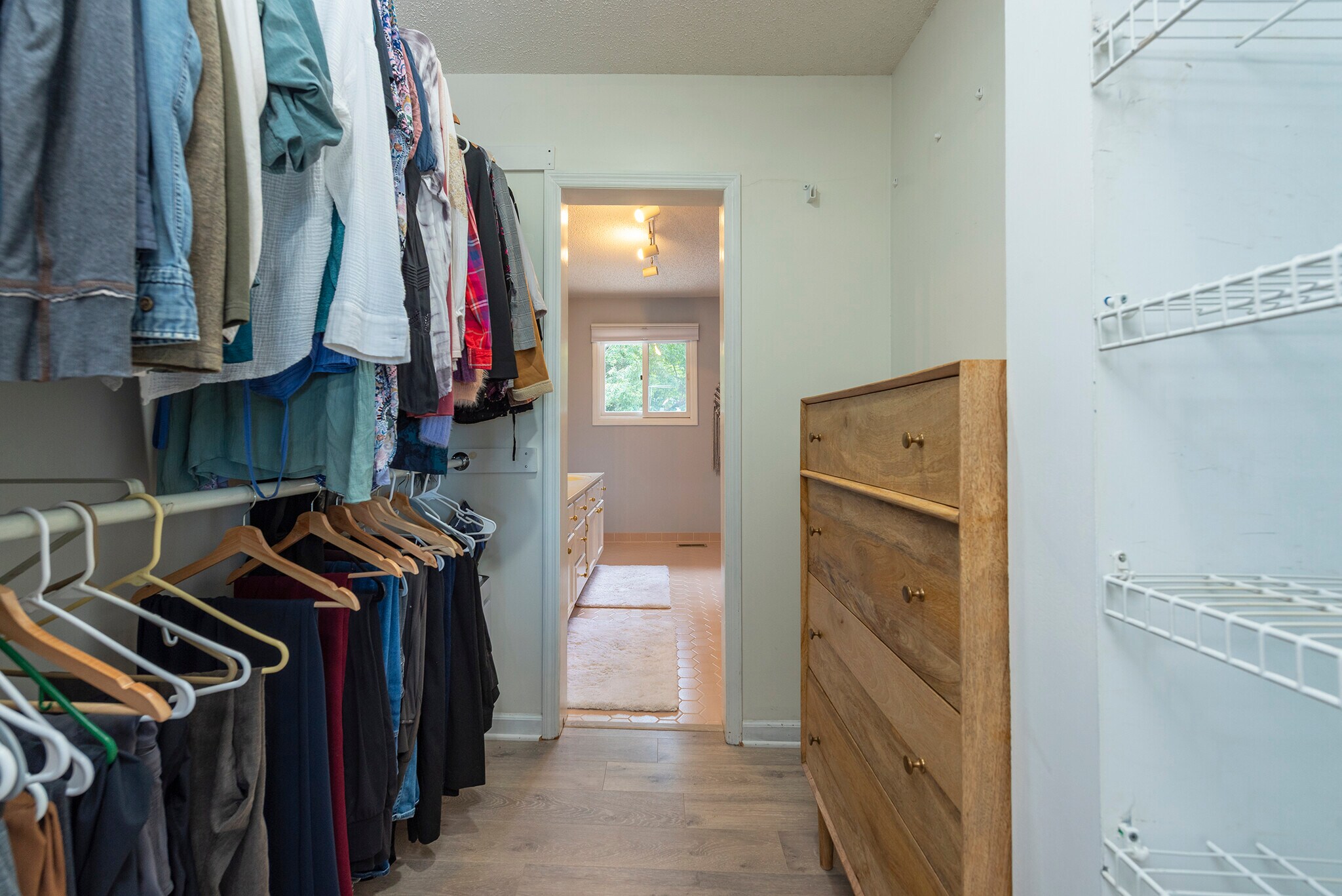 Deep walk-through boutique closet providing extensive wardrobe storage and seamless bathroom. - 405 Windswept Dr
