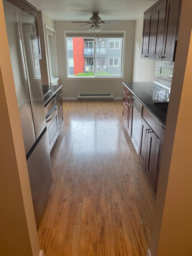 looking through kitchen from front entry. dining area beyond. (facing west) - 7001 Sand Point Way NE