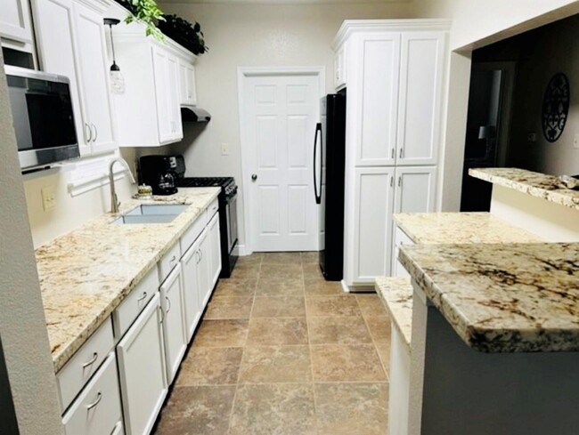 Granite counters in this modern kitchen. - 405 Winnie St