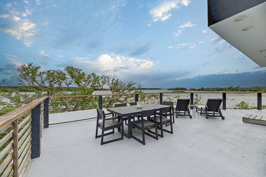 Large outdoor rooftop patio with dining table, lounge seating, and expansive marsh views - 2179 Sol Legare Rd