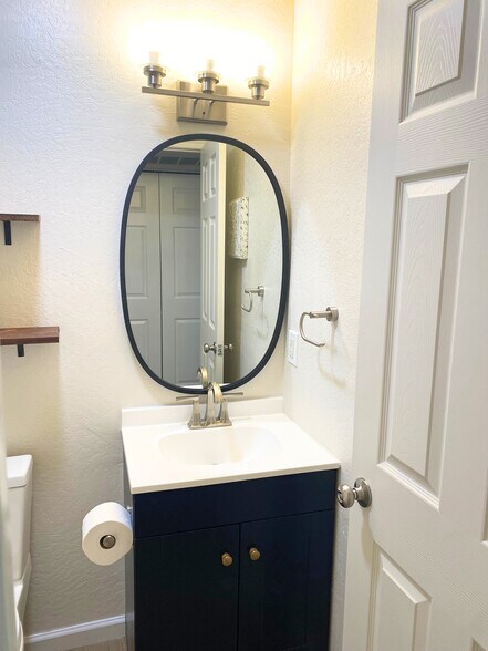 Bathroom setup featuring a stylish sink, mirror, convenient shelves-perfect for your essentials. - 1795 W 28th St
