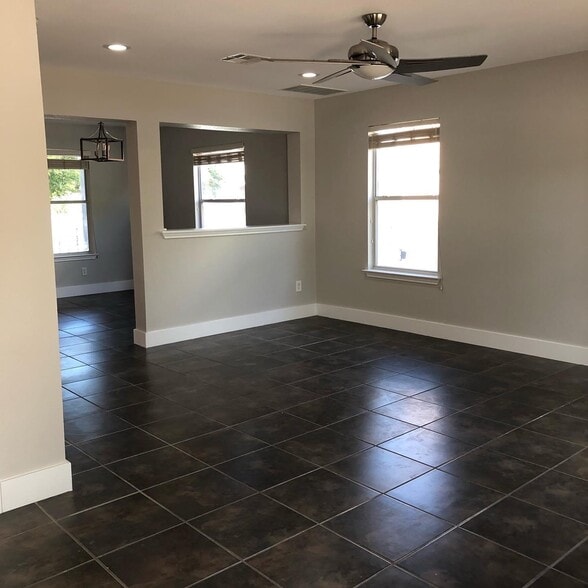 Living area with recessed lighting, updated fixtures, oversize baseboard, tile flooring - 615 Big Spring Dr