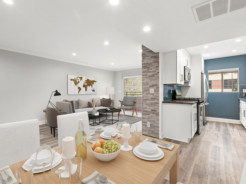 Hardwood floored dining room with view of living room and kitchen. - Catalina Apartments