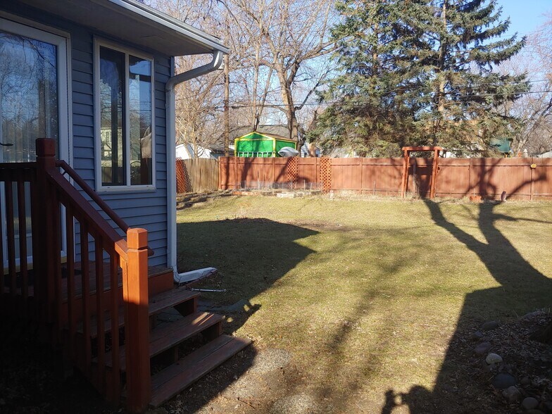 View of the sunroom and backyard with the garden in the distance. - 7415 1st Ave S