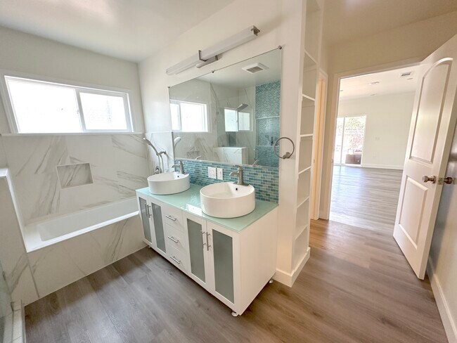 Master Bathroom Backyard Facing with walk in shower, tub, storage, and walk-in closet - 1241 Elmer St