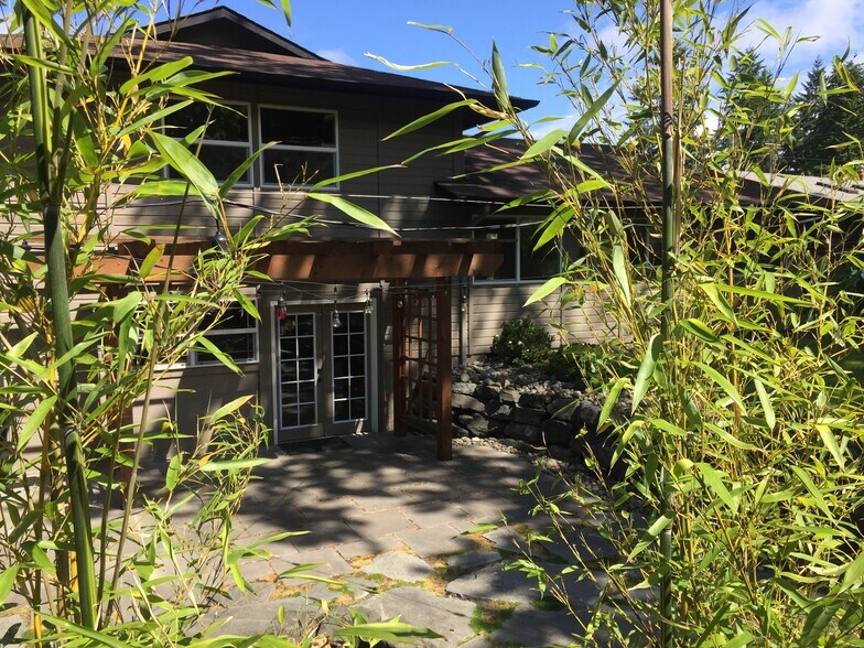 Landscaped backyard with rock walls and stone patio - 8514 41st St W