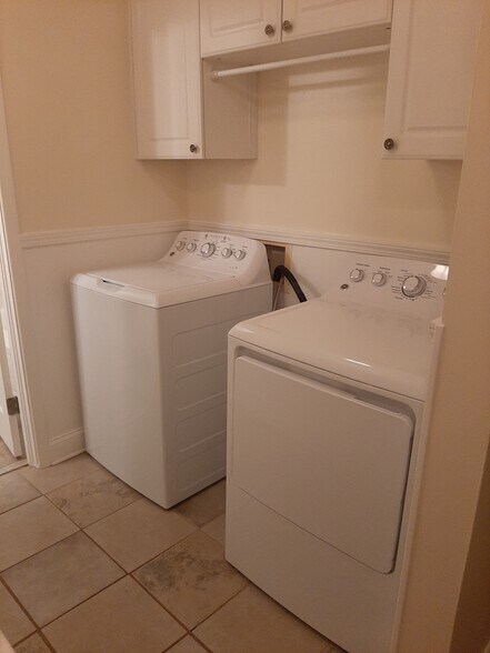 Dedicated laundry area, with washer/dryer included. Linen storage cabinets above. - 2955 Fantasy Ln