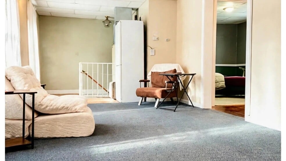 Furnished living room view with a lounger, brown chair folds into a single bed. Storage closet! - 76 N Main St