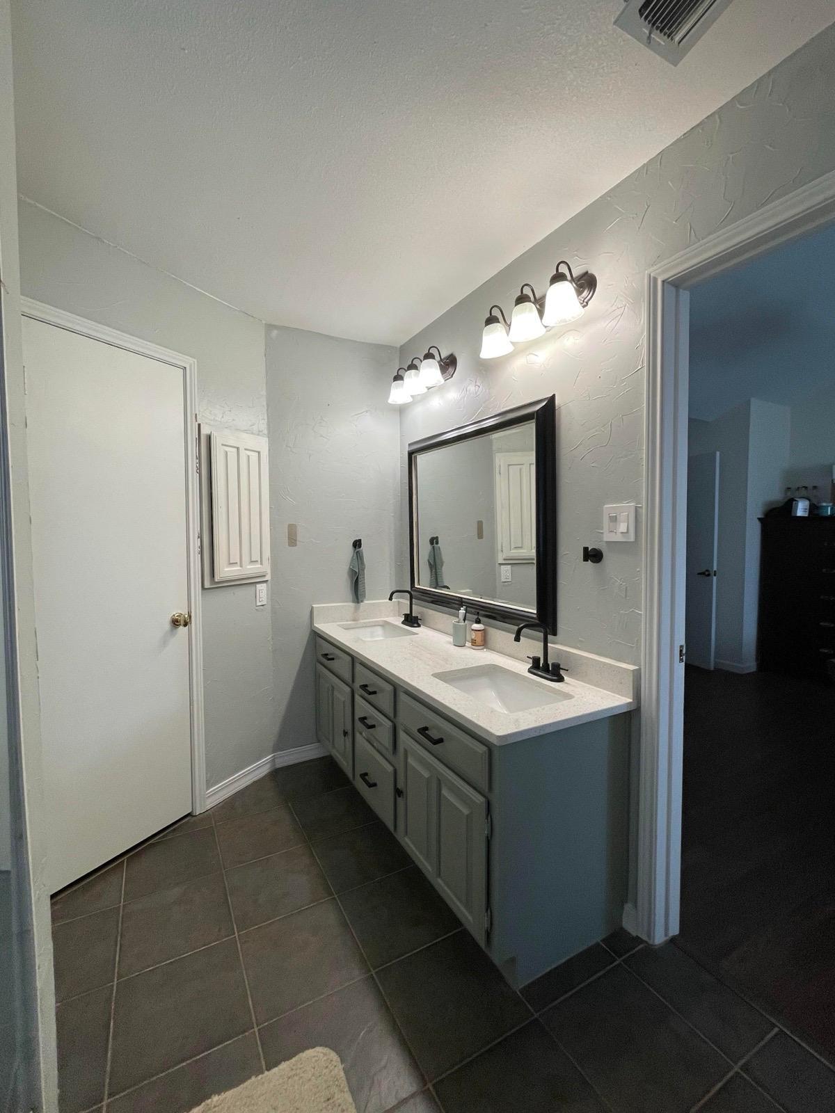 Updated bathroom with twin sinks, great lighting, and ample storage. - 2401 Thistle Ct