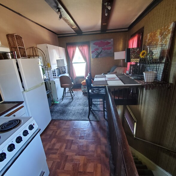 Stairs on right, living area, stove, fridge. - 3829 SE Washington St