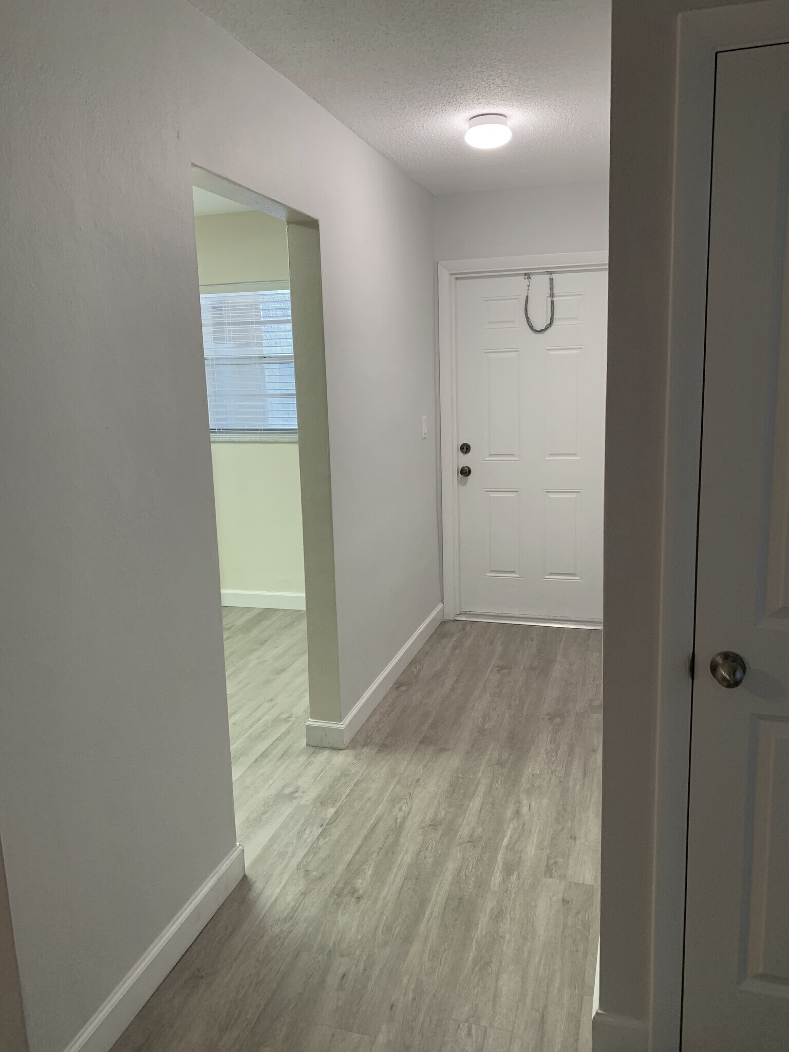 View of Hallway, Front Door and Kitchen Entry on Left - 1400 NE 57th St