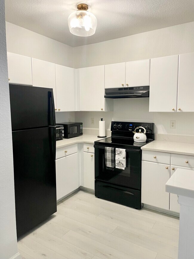 Recently painted white cabinets with gold knobs + faux marble quartz countertops - 304 E South St