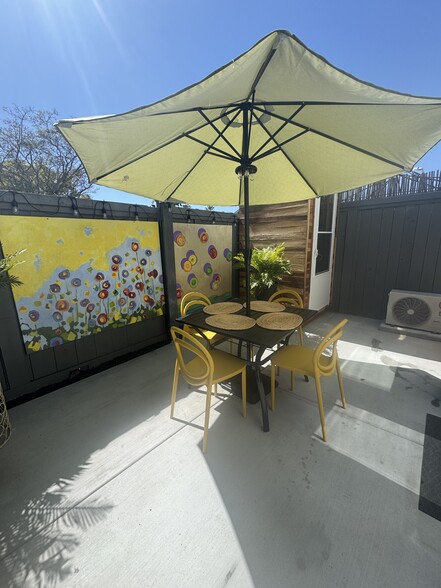 art-filled yard with dining table and laundry center in corner - 3744 Granada Ave