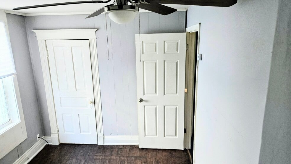 The bedroom number one has original vintage doors, wall indoor trims, ceiling fan and modern closet - 3348 Bohannon Ave