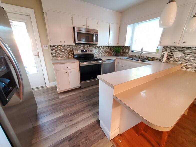 Kitchen with stainless appliancess and access to screened porch - 621 Broadview Dr