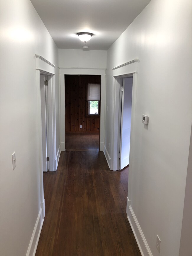 Hallway with new lighting, new trim, fresh paint and refinished floors. - 2205 Mayflower Dr