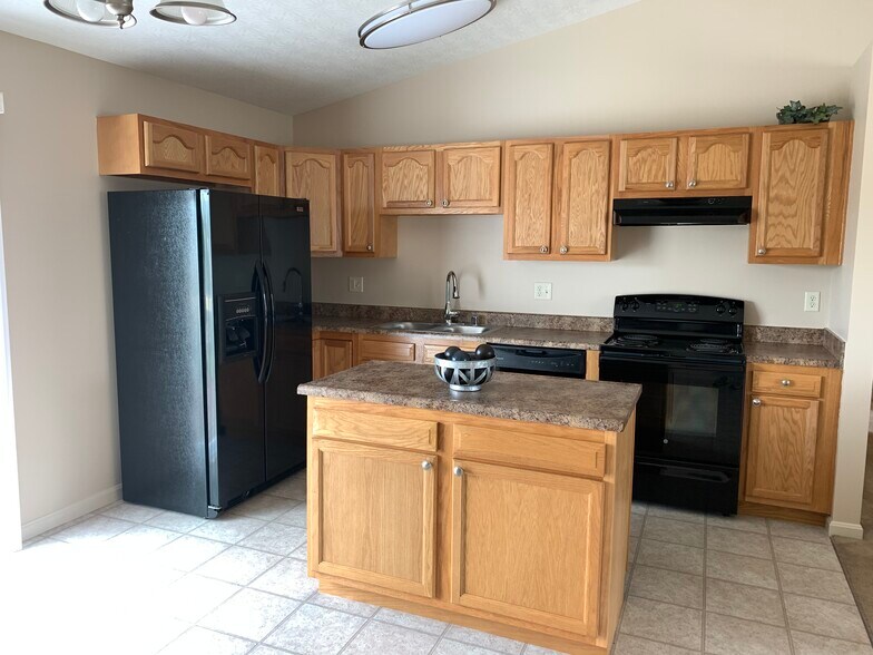 Bright and open kitchen with sleek, black appliances and tons of cabinets - 6869 Gordon Blvd