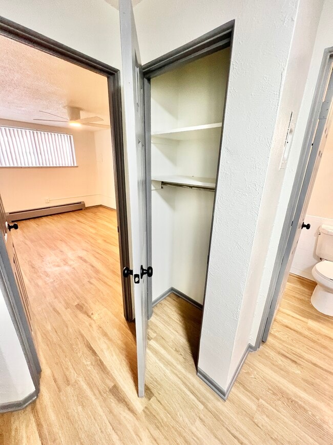 Explore this chic living space with sleek design, ample storage, and warm wooden tones. - Melody Apartments