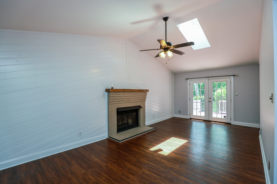 Living room with skylight and gas fireplace. - 701 Marbleridge Rd