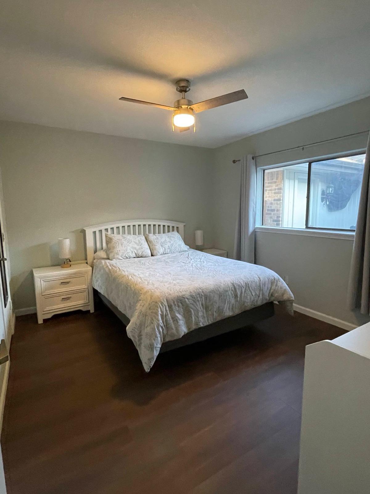 Comfortable guest room with queen bed, closet, and large window. - 2401 Thistle Ct