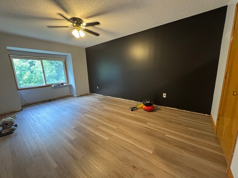 Master bedroom with a ceiling fan and large walk in closet. Trim will be finished before move in - 705 Lake Ave