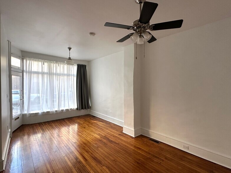 Living room with old storefront window. Room is 20'4" x 11'5". - 336 Fitzwater St