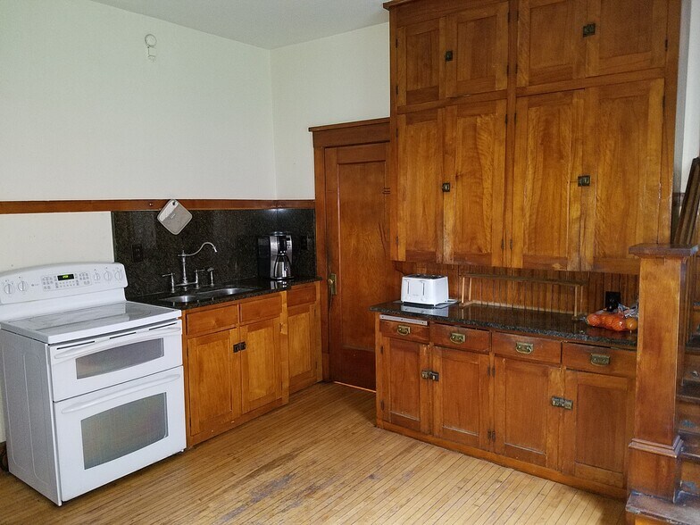 Eat in kitchen with original maple cabinets. Granite counters, upper end side by side fridge with filtered water and ice. Double oven and flat top range. - 106 SE 2nd Ave