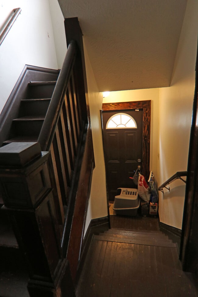 View of stairways to 2nd floor and basement with side exterior door - 372 E Oakland Ave