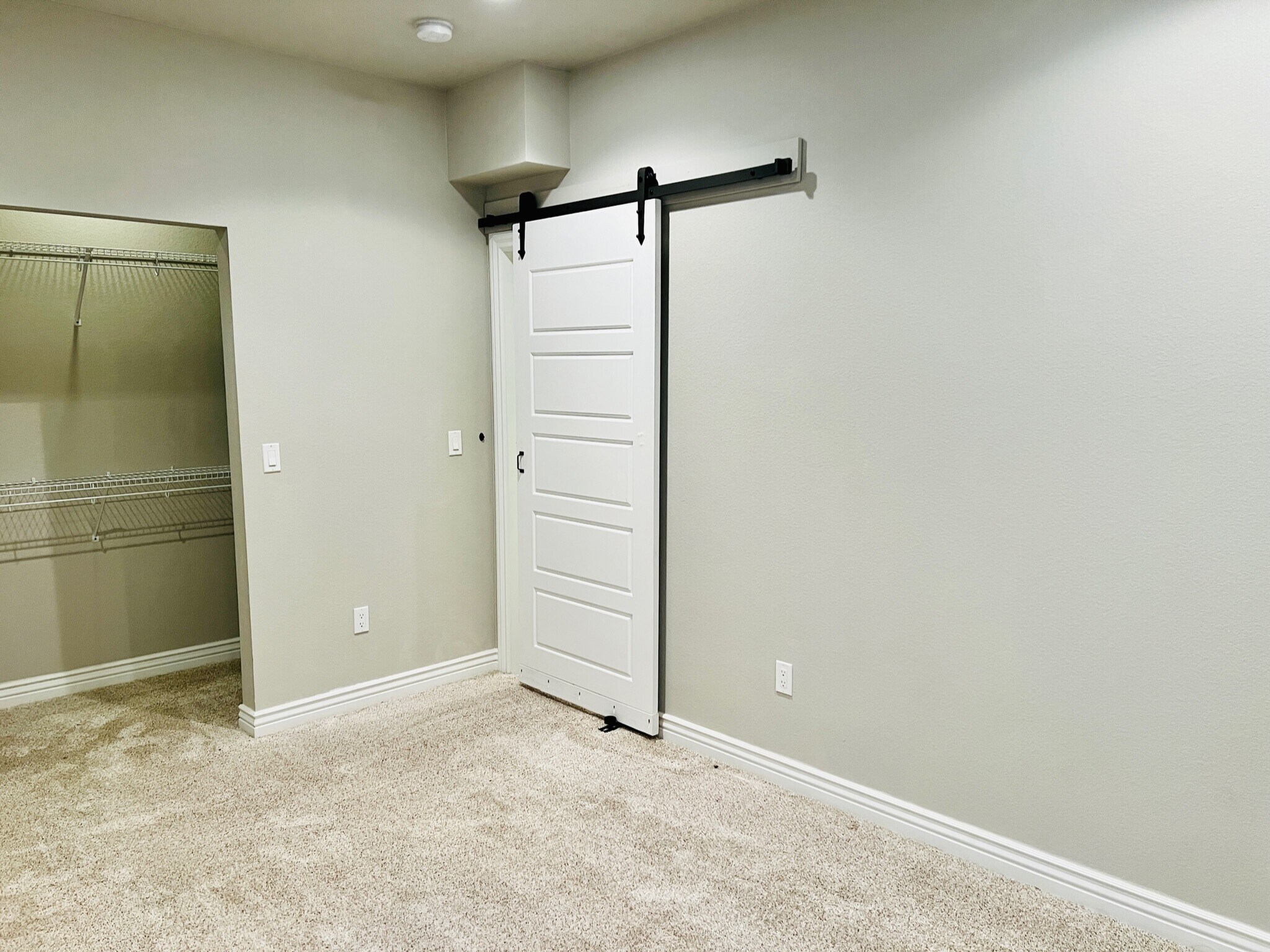 Basement bedroom with lots of shelving and storage that extends past the wall. - 2317 Decatur St