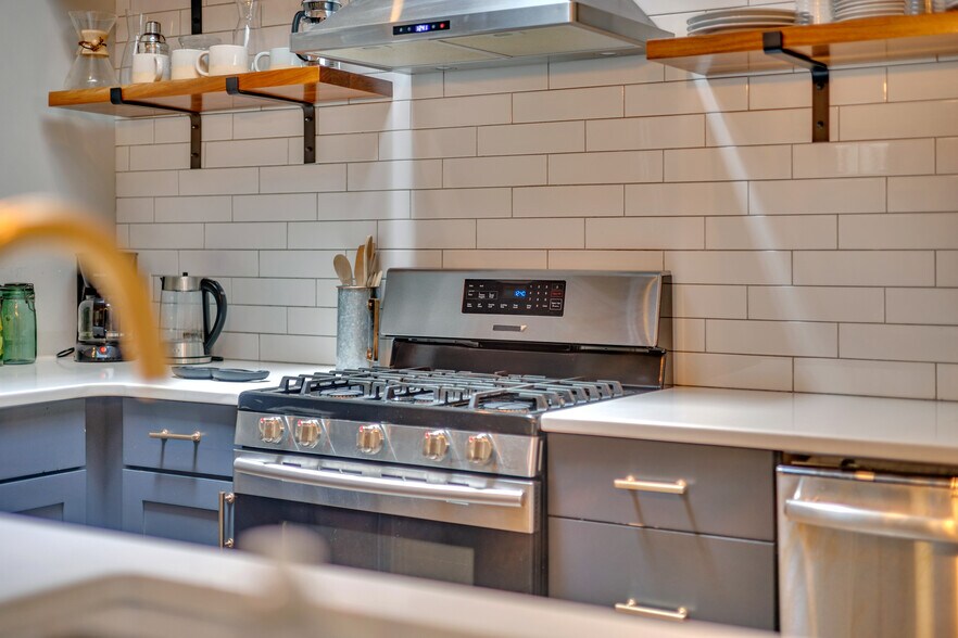 The kitchen is fully equipped with all new stainless steel appliances including a large fridge, stov - 1876 DeKalb Ave NE