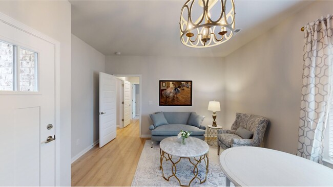 A living room stands in the center of the Efficiency suite, ready to be transformed - 15747 Ruthie Lynn Dr