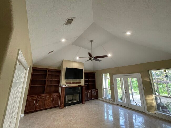 Living room with wet bar, high vaulted ceilings, recess lighting, custom wood cabinets, chimney - 600 River Bend Dr
