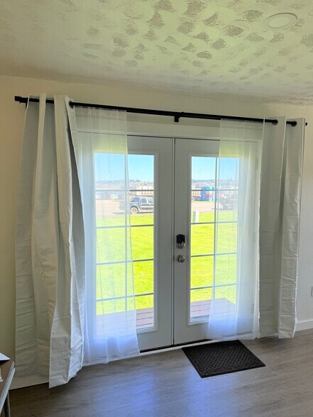 French door entrance with grass and river across the way - 103 A St