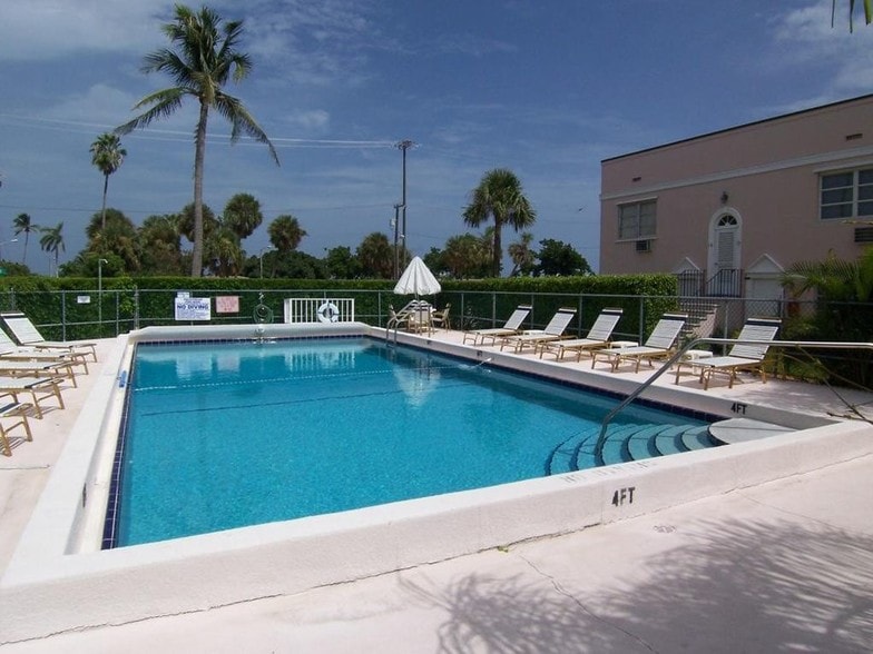 Lounge on the patio of your 8-foot deep pool, which is hidden from street view by lush hedges. - 15 S Golfview Rd