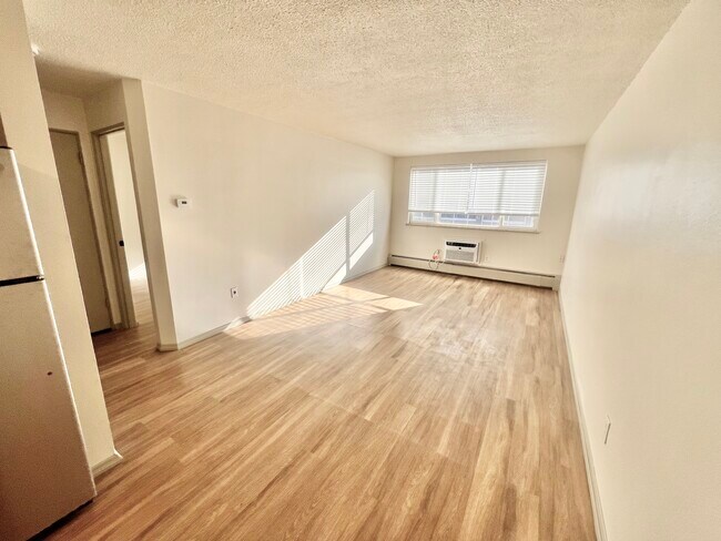 Immerse yourself in this airy living space filled with warmth and light. - Harmony Apartments